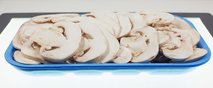 Agaricus bisporus aka champignons mushrooms in a tub on a table