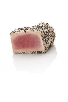 Grilled tuna steak wrapped in black and white sesame isolated on white background. Culinary seafood eating. 