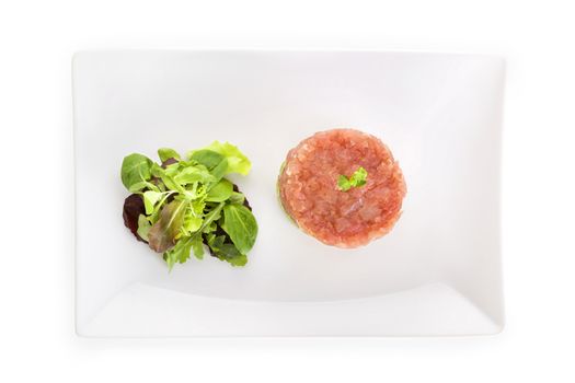 Delicious salmon tartare with fresh salad on white tray isolated on white, top view. Healthy eating.