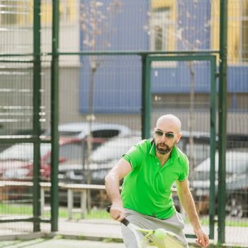 young man play tennis outdoor on tennis field at early morning