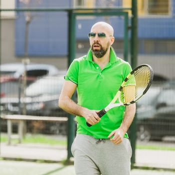 young man play tennis outdoor on tennis field at early morning