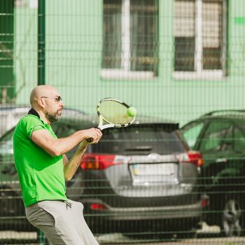 young man play tennis outdoor on tennis field at early morning