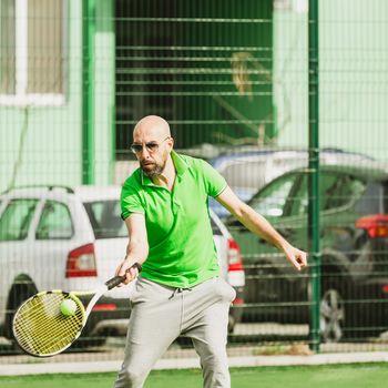 young man play tennis outdoor on tennis field at early morning