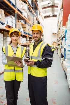 Warehouse team smiling at camera in a large warehouse