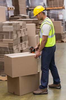 Worker in warehouse preparing goods for dispatch