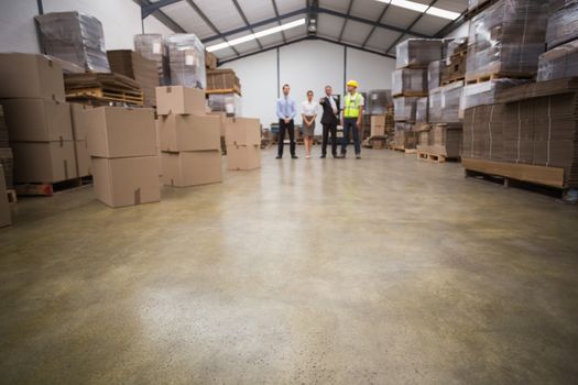 Warehouse managers and worker talking together in a large warehouse