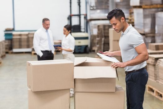 Warehouse manager checking his inventory in a large warehouse