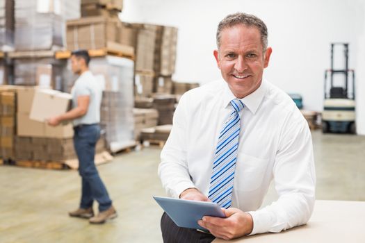 Portrait of male boss using digital tablet in warehouse