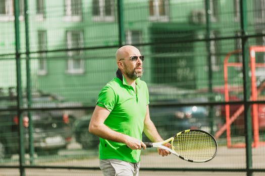 young man play tennis outdoor on tennis field at early morning