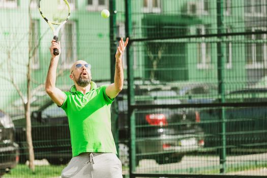 young man play tennis outdoor on tennis field at early morning