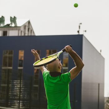 young man play tennis outdoor on tennis field at early morning