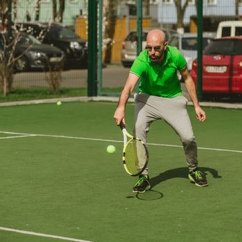 young man play tennis outdoor on tennis field at early morning