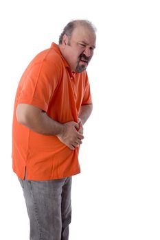 Middle-aged man with constipation grimacing in pain as he clutches his stomach in discomfit due to compaction of his feces and inability to enjoy a regular bowel movement
