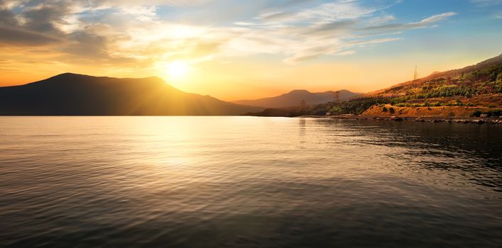 Calm sea and mountains at the beautiful sunset