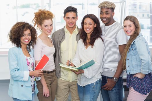 Fashion students smiling at camera together at the college