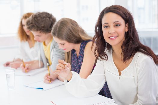 Fashion students smiling at camera in class at the college