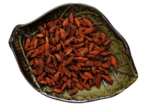 dried goji berries (wolfberry in a leaf shaped ceramic bowl isolated on white