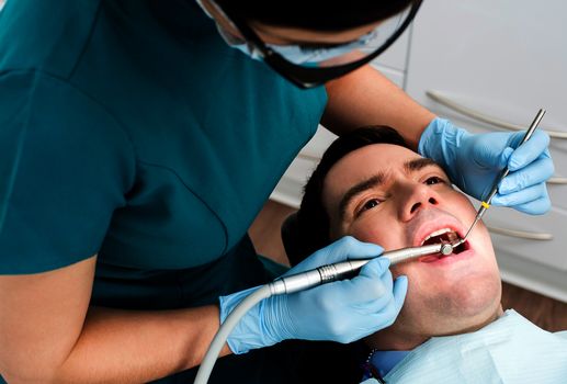 Male with open mouth during oral checkup at dentist