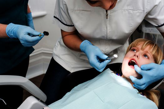 Cropped image of little girl under dental treatment