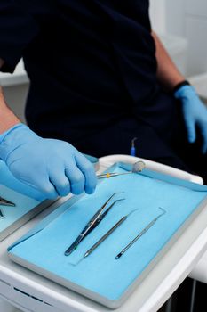 Cropped image of dentist picking up tool for examine