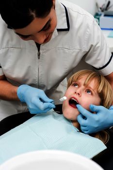 Dental assistant examine a little girl 