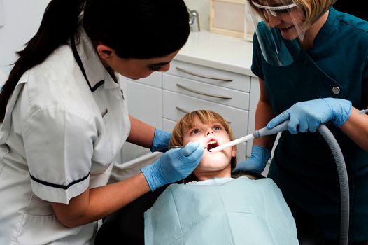 Dentist and nurse are curing a little girl patient
