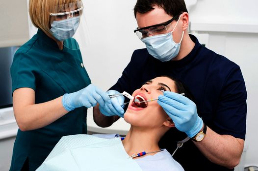 Male dentist treat the female patient mouth 