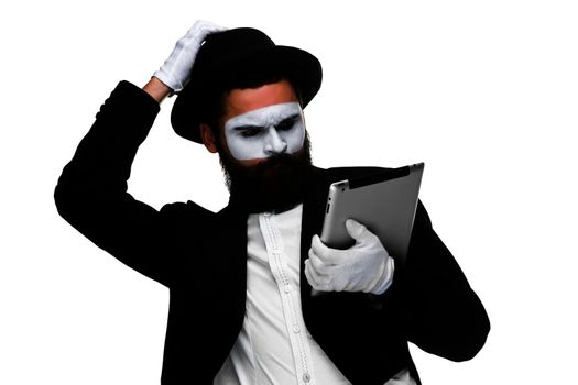 Man with a face mime working on a laptop isolated on a white background. concept of thinking in business