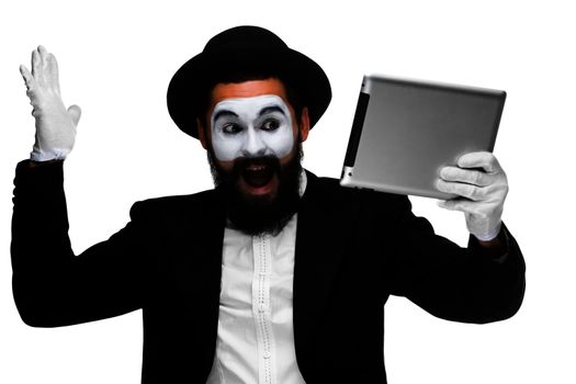 Man with a face mime working on a laptop isolated on a white background. concept of thinking in business