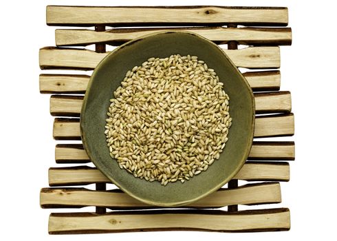 sprouted brown rice in a ceramic bowl on a wood stick trivet