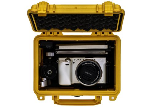 FORT COLLINS, CO, USA, April 25,  2015:  Sony A6000 mirrorless digital camera with a mini  tripod and spare battery in a waterproof pelican case ready for adventure trip.