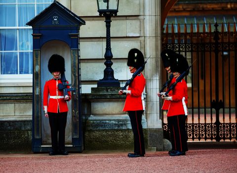 LONDON - APRIL 13: Queen's Guards at the Buckingham palace on April 13, 2015 in London, UK. It's the name given to the contingent of infantry guarding Buckingham Palace and St James's Palace.