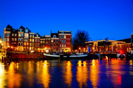 Night city view of Amsterdam, the Netherlands with Amstel river