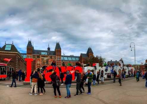 AMSTERDAM - APRIL 16: I Amsterdam slogan with crowd of tourists on April 16, 2015 in Amsterdam. Located at the back of the Rijksmuseum on Museumplein, the slogan quickly became a city icon.