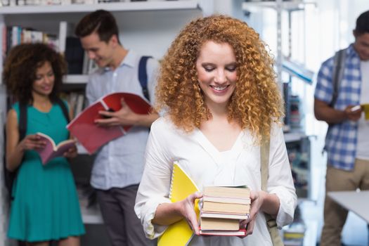 Student carrying small pile of books at the college