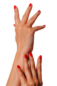 Woman with beautiful manicured red fingernails gracefully crossing her hands to display them to the viewer on a white background in a fashion, glamour and beauty concept