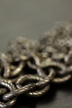 Assorted silver costume jewellery with a jumbled pile of chains with different shaped links, a clear crystal bead and a necklace of round silver beads with focus to the chains