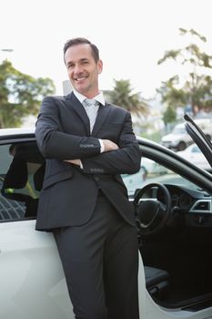 Handsome businessman smiling at camera in his car
