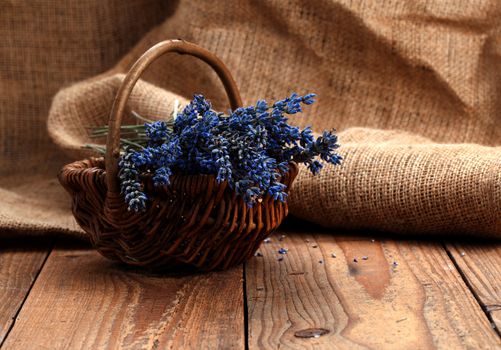 dry lavender flower in a basket, on wooden background