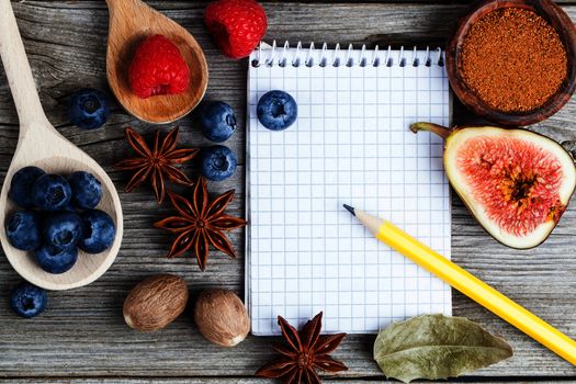 top view of recipe book with ingredients on wooden table