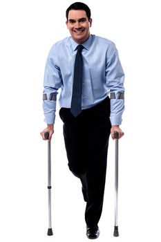 Executive man trying to walk with crutches