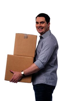 Sideways of happy casual man carrying cartons