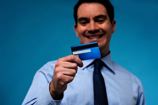 Smiling corporate man looking his new debit card