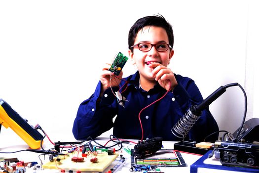 Young student performs experiments in electronics and dreams of the future.