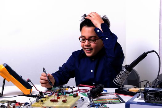 Young student performs experiments in electronics and dreams of the future.