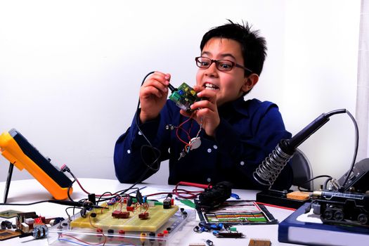 Young student performs experiments in electronics and dreams of the future.