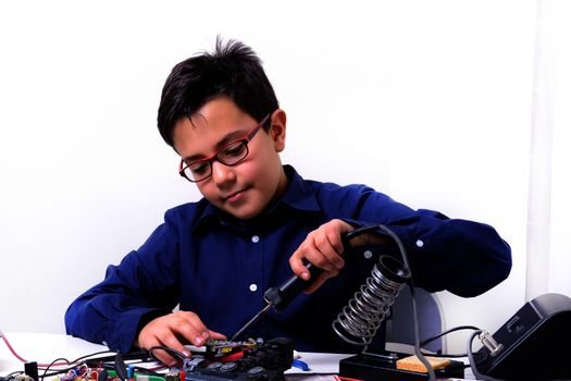 Young student performs experiments in electronics and dreams of the future.