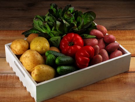 Arrangement of Raw Potatoes, Cucumbers, Tomatoes and Butterhead Lettuce on White Wooden Box on Rustic background