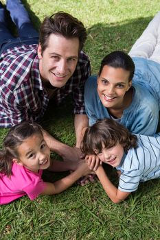 Happy family smiling at camera on a sunny day