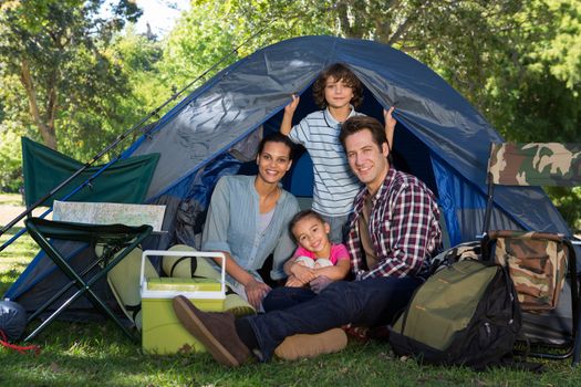 Happy family on a camping trip in their tent on a sunny day